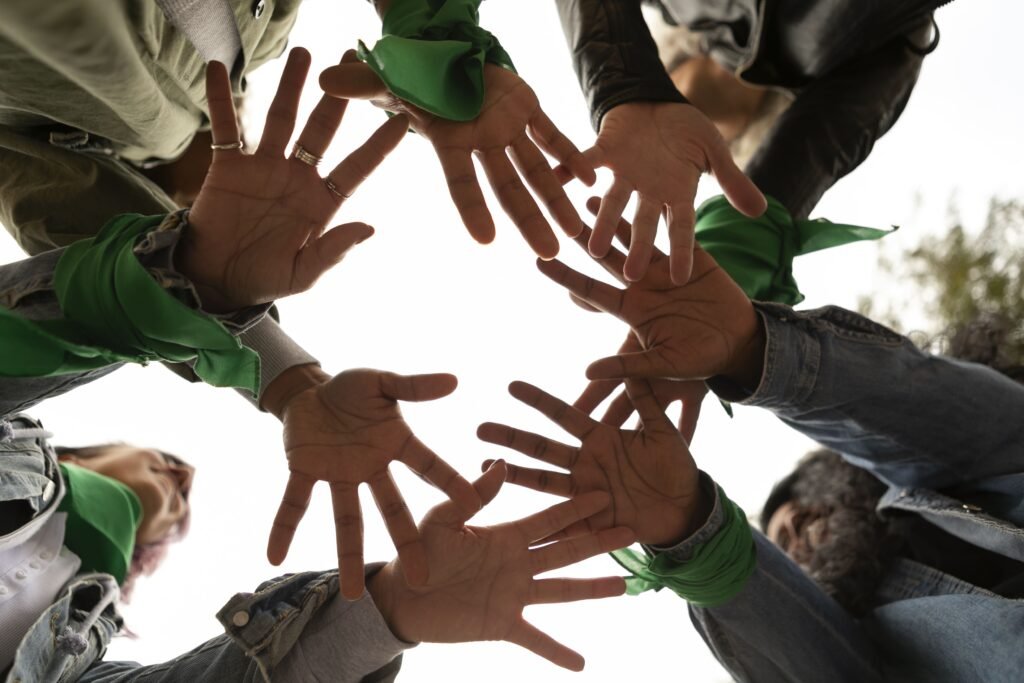 mujeres apoyando sus manos con otras mujeres